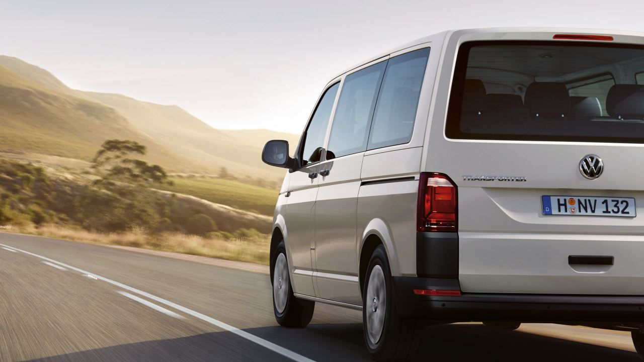 Ein VW Transporter fährt durch eine karge Landschaft.