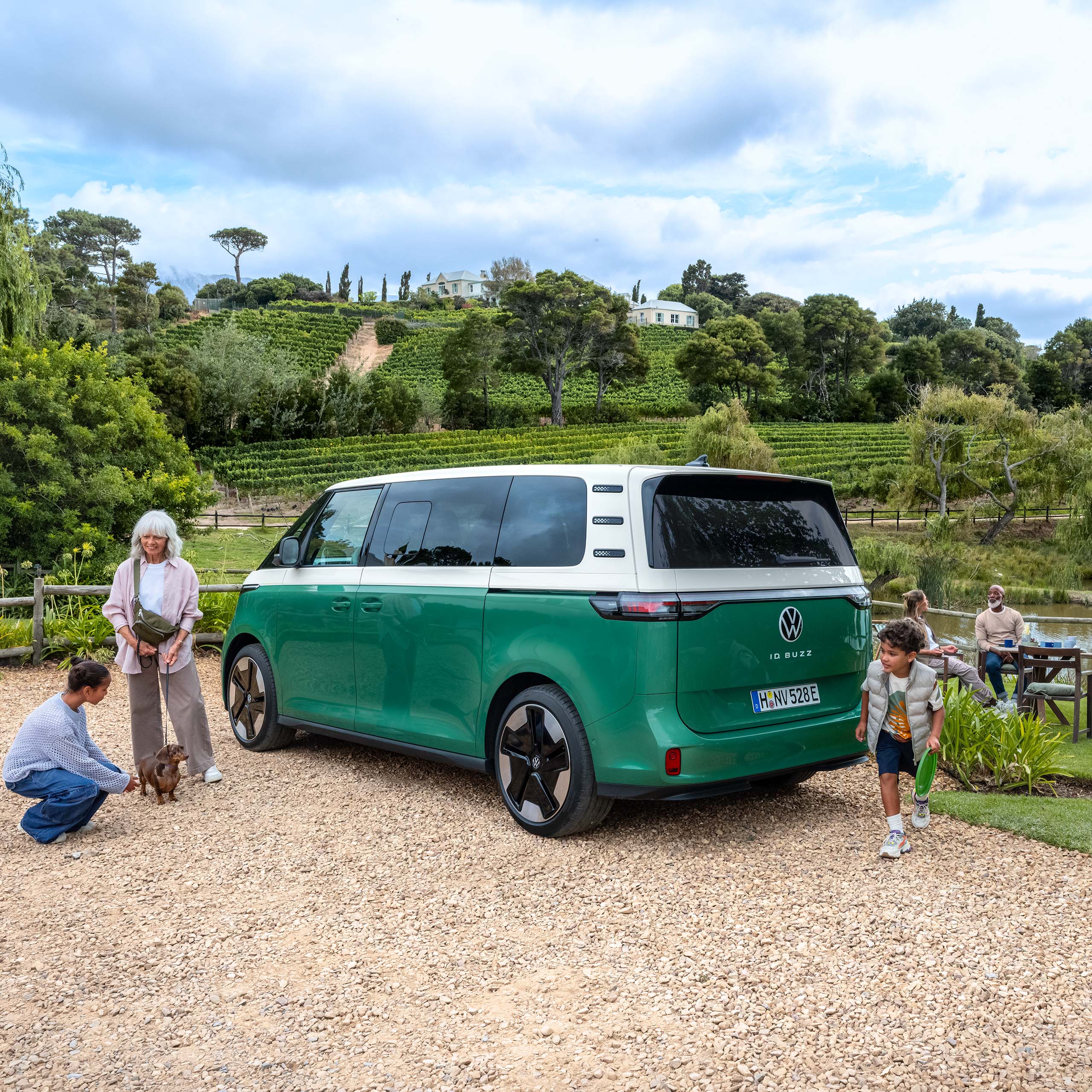 Eine Familie campt mit ihrem VW ID. Buzz an einem See.